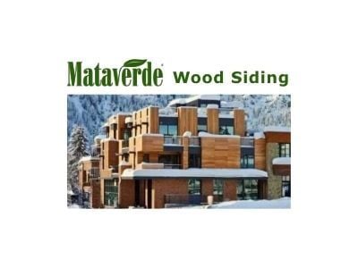  The Mataverde Wood Siding logo is above a luxury modern facade. Garapa wood siding is installed both horizontally and vertically on the building, set against a snow-covered mountain, showcasing stunning wood siding.